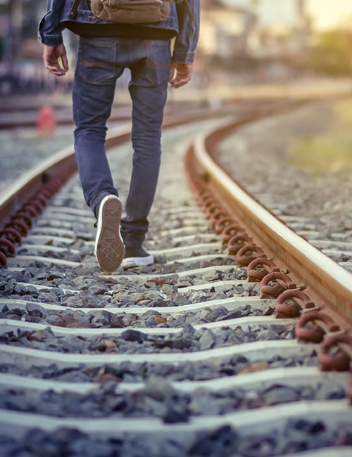 Person steht im Feld vor untergehender Sonne
